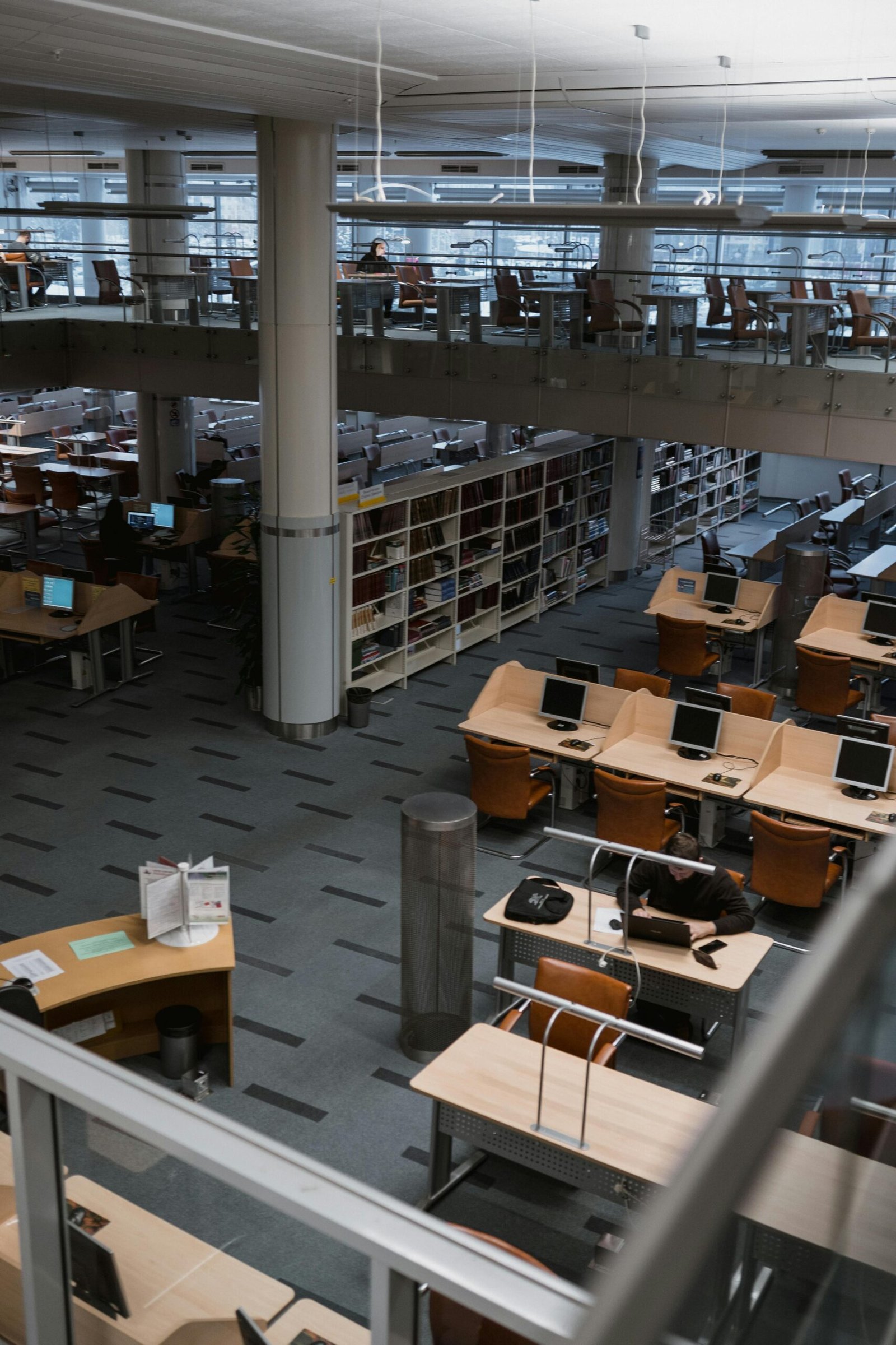 Spacious library interior featuring bookshelves and computer desks in a well-lit modern space.