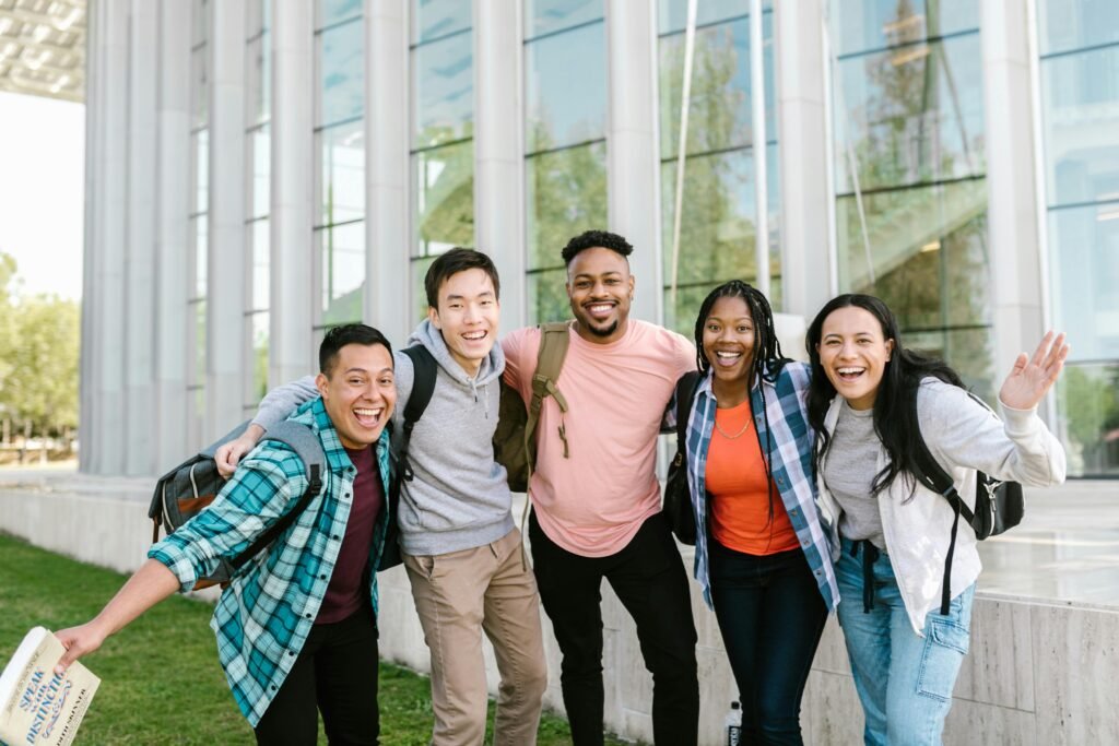 pexels photo 7683745 7683745 A happy group of diverse college students posing cheerfully outside a modern building.