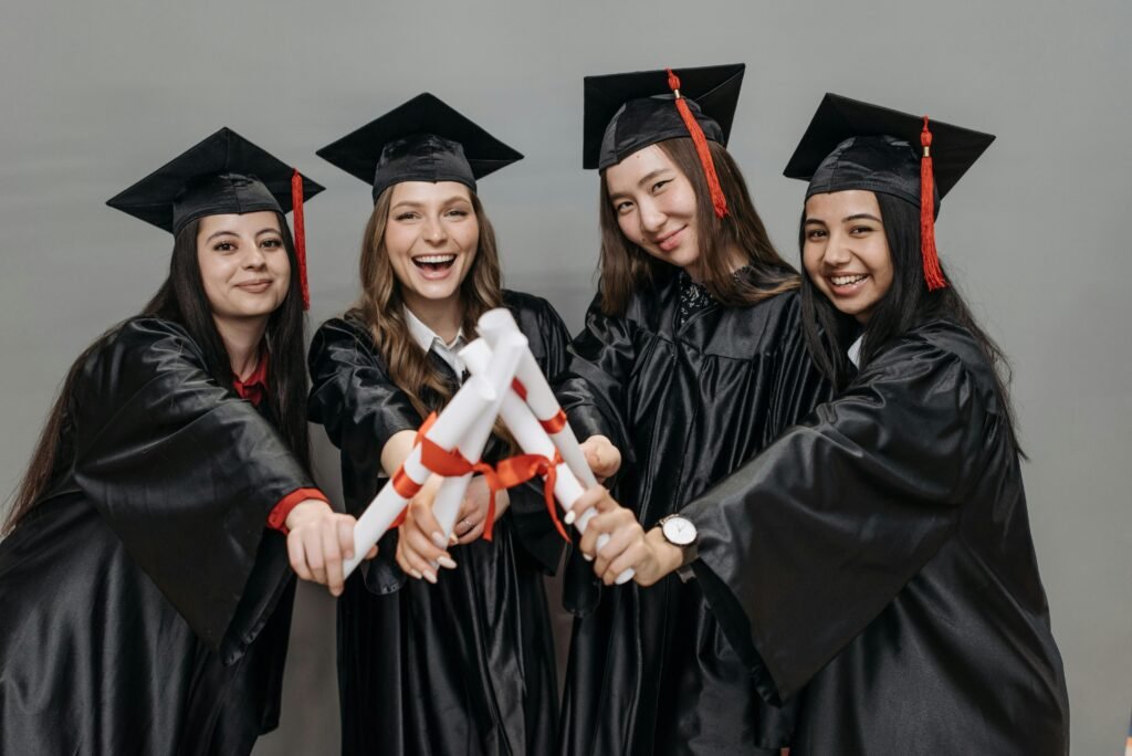 pexels photo 7944035 7944035 A joyful group of women in graduation gowns holding diplomas.