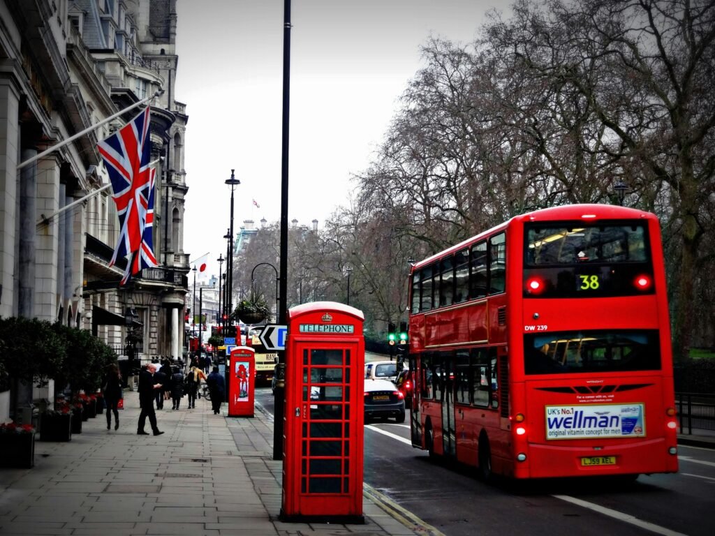 london street phone cabin 163037 163037 Classic London scene featuring a red double-decker bus and iconic phone booth on a busy city street.