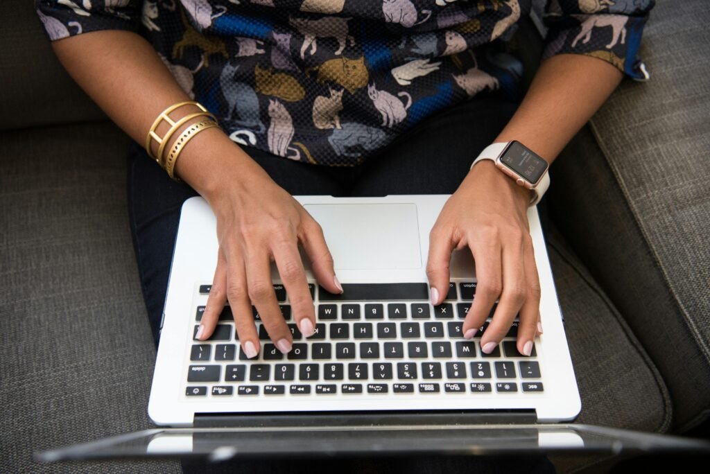 pexels photo 1181511 1181511 Close-up of a woman's hands typing on a laptop with an Apple Watch and bracelets.