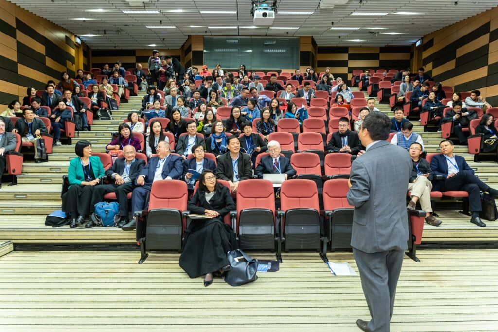 pexels photo 1709003 1709003 Professional setting of a business conference with attendees and a presenter in an auditorium. (Guest lectures)