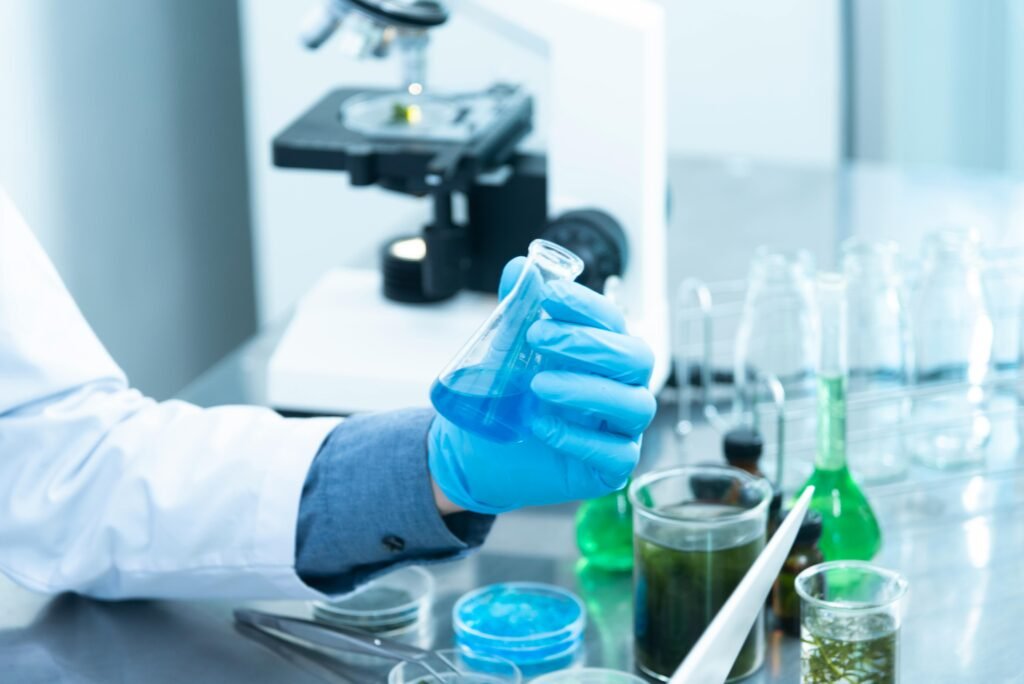 pexels photo 2280571 2280571 Scientist in gloves analyzing blue liquid in a laboratory setting with microscope and glassware.