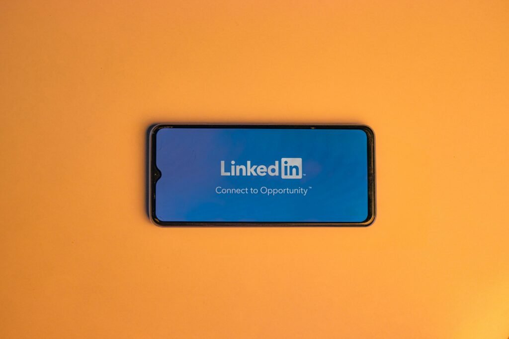 pexels-photo-16564260-16564260 Smartphone showing LinkedIn login on vibrant orange background, symbolizing connectivity.