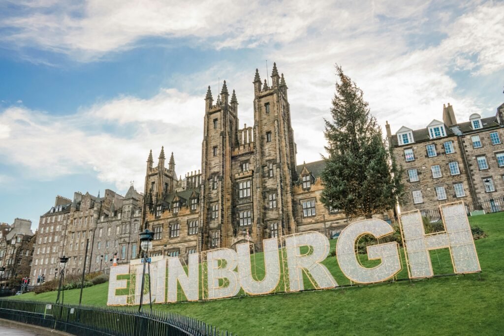 Iconic Edinburgh architecture with illuminated sign and scenic backdrop.