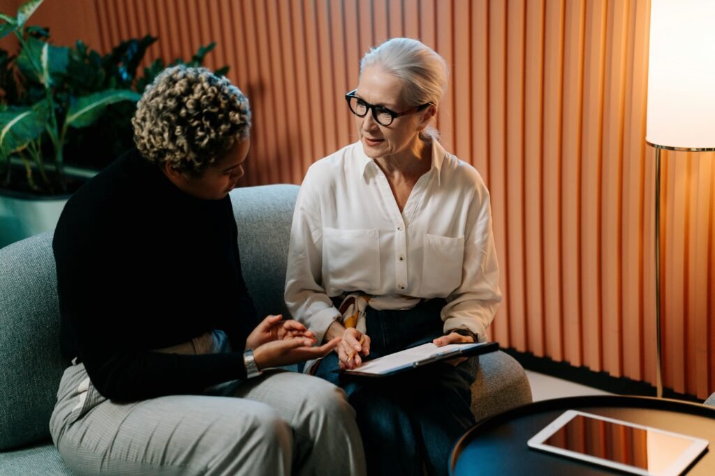Two women in a career centre engaged in a business discussion indoors with documents.